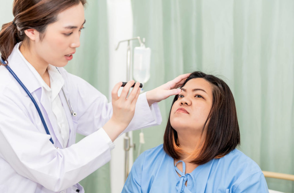 A patient's eye is being examined by an eye care professional to find the cause of her halo vision.