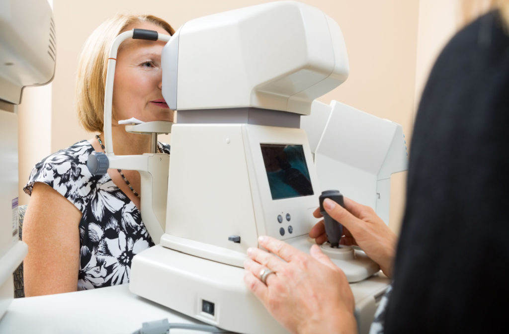 A woman at an eye clinic having a puff of air eye test to monitor for eye conditions such as glaucoma.