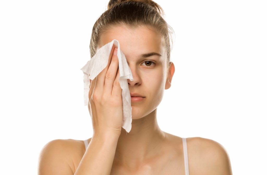 A woman holding a warm compress on her eye.