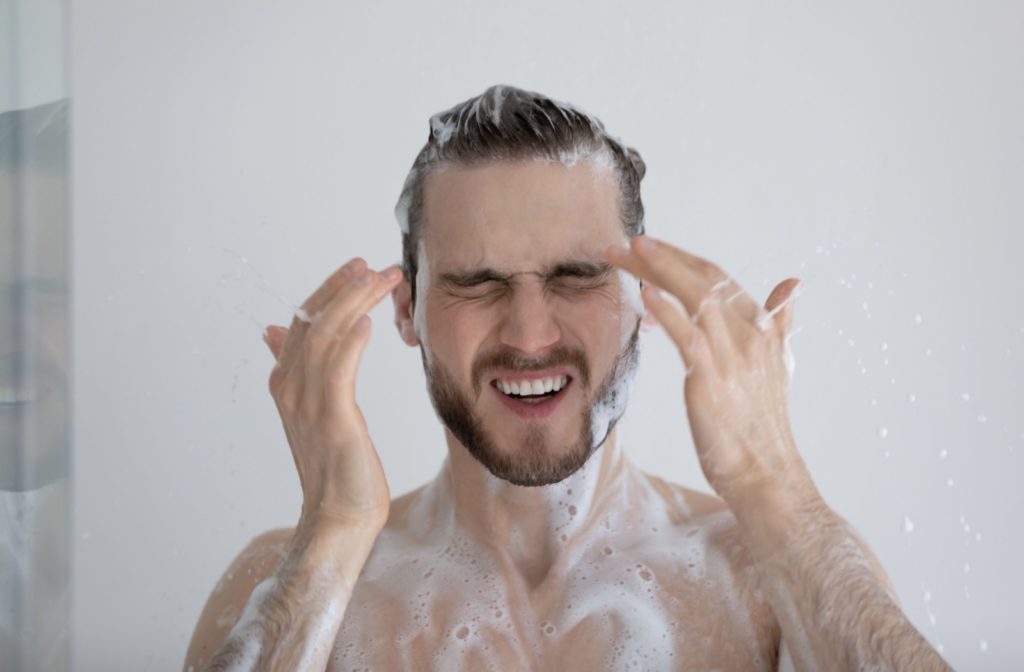 Man in the shower experiencing a burning sensation in his eyes.