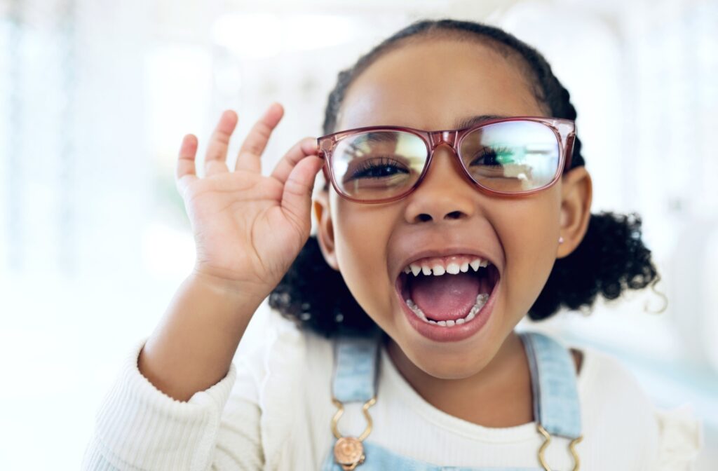 A young child wearing a pair of eyeglasses from their optometrist.